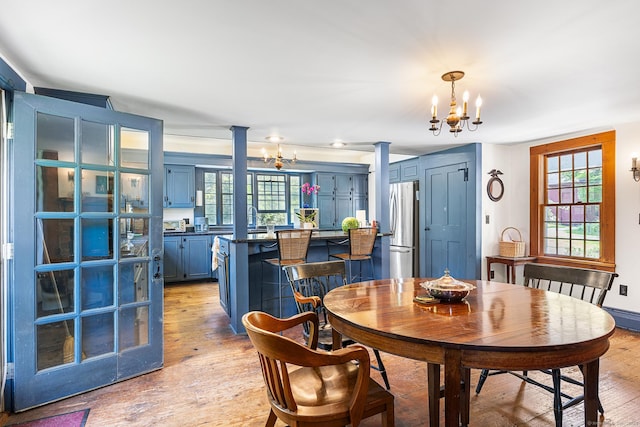 27 Tobey Hill Rd, North Canaan, CT 06018 - dining space with a chandelier, light wood finished floors, ornate columns, and healthy amount of natural light