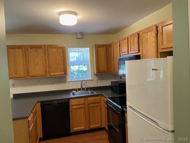 150 Forest Rd Unit 40, Milford, CT 06461 - kitchen featuring black appliances, a sink, dark countertops, and decorative backsplash