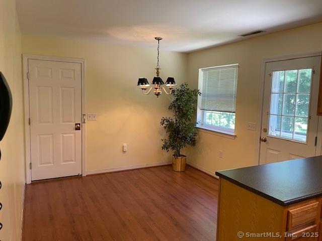 150 Forest Rd Unit 40, Milford, CT 06461 - unfurnished dining area featuring a chandelier, wood finished floors, and baseboards