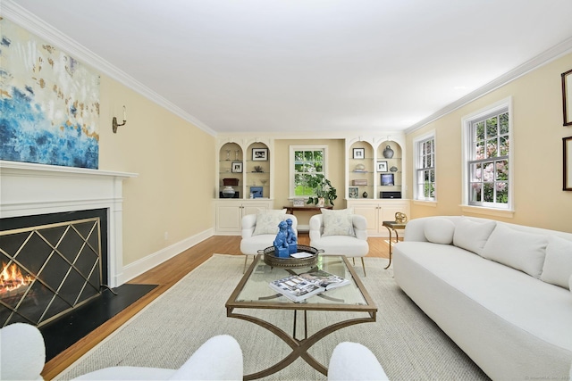 151 Woodridge Dr, New Canaan, CT 06840 - living area featuring wood finished floors, built in shelves, a lit fireplace, ornamental molding, and baseboards