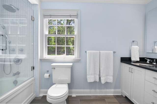151 Woodridge Dr, New Canaan, CT 06840 - bathroom featuring vanity, baseboards, toilet, and bath / shower combo with glass door