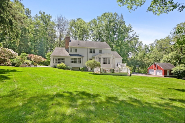 151 Woodridge Dr, New Canaan, CT 06840 - back of house featuring an outdoor structure, a deck, a chimney, a garage, and a lawn