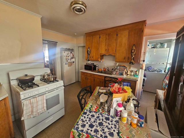102 Mapleton St, Hartford, CT 06114 - kitchen featuring white appliances, stacked washing machine and dryer, brown cabinetry, a sink, and ornamental molding