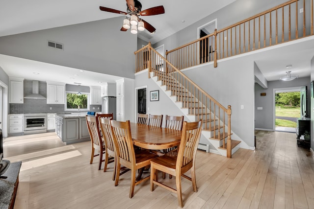 233 Church St, Hebron, CT 06231 - dining room with high vaulted ceiling, a ceiling fan, stairs, and light wood-style flooring