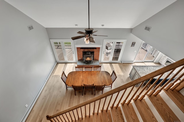 233 Church St, Hebron, CT 06231 - dining room featuring ceiling fan, wood finished floors, a wood stove, a baseboard radiator, and stairs