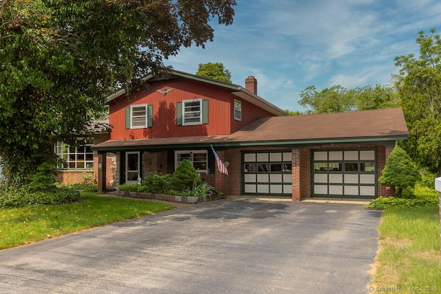 3 Glen Dr, Old Saybrook, CT 06475 - traditional-style house with asphalt driveway, a chimney, a garage, and brick siding