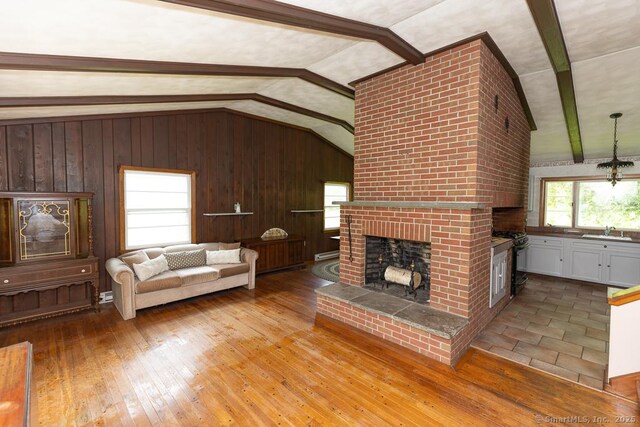 3 Glen Dr, Old Saybrook, CT 06475 - living room with vaulted ceiling, a fireplace, wooden walls, and wood-type flooring