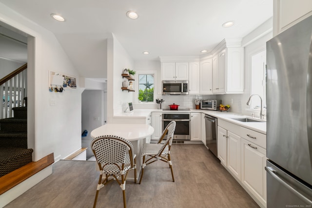 407 Meadowbrook Rd, Fairfield, CT 06824 - kitchen with stainless steel appliances, white cabinetry, a sink, recessed lighting, and backsplash