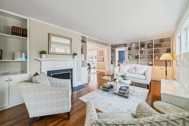 407 Meadowbrook Rd, Fairfield, CT 06824 - living room featuring built in shelves, dark wood-style floors, a premium fireplace, and crown molding
