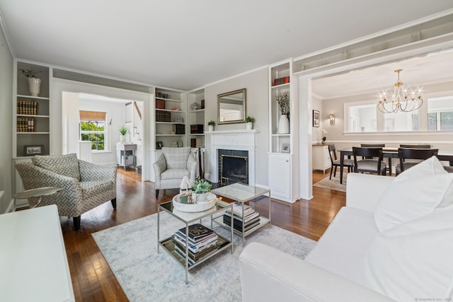 407 Meadowbrook Rd, Fairfield, CT 06824 - living area with a fireplace, dark wood-type flooring, crown molding, a chandelier, and built in shelves