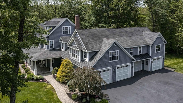 112 John Hand Dr, Coventry, CT 06238 - shingle-style home with a chimney, an attached garage, driveway, a shingled roof, and covered porch