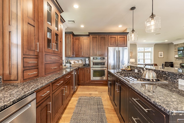 112 John Hand Dr, Coventry, CT 06238 - kitchen with stainless steel appliances, light wood-style flooring, dark stone counters, hanging light fixtures, and recessed lighting