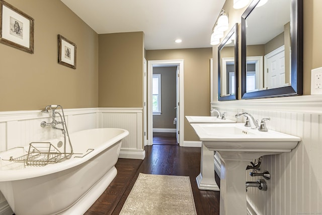 112 John Hand Dr, Coventry, CT 06238 - bathroom featuring wood finished floors, a wainscoted wall, a soaking tub, and a sink