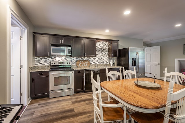 112 John Hand Dr, Coventry, CT 06238 - kitchen with stainless steel appliances, dark brown cabinets, light wood finished floors, tasteful backsplash, and recessed lighting