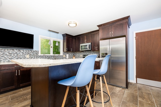 20 Roundhill Rd, Granby, CT 06035 - kitchen with appliances with stainless steel finishes, backsplash, light countertops, and dark brown cabinets