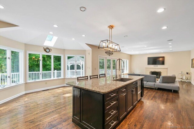 1 Mountaincrest Dr, Cheshire, CT 06410 - kitchen featuring a sink, open floor plan, a fireplace, dark wood-style floors, and light stone counters