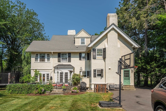 262 Kenyon St, Hartford, CT 06105 - back of house with entry steps, stucco siding, a chimney, a lawn, and a patio