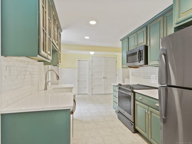 355 Main St, Old Saybrook, CT 06475 - kitchen featuring appliances with stainless steel finishes, green cabinetry, recessed lighting, backsplash, and light floors