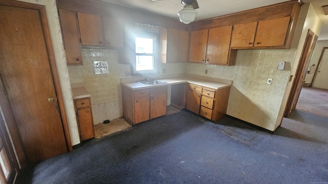215 Stanley St, New Britain, CT 06051 - kitchen with a sink, dark carpet, brown cabinetry, and light countertops