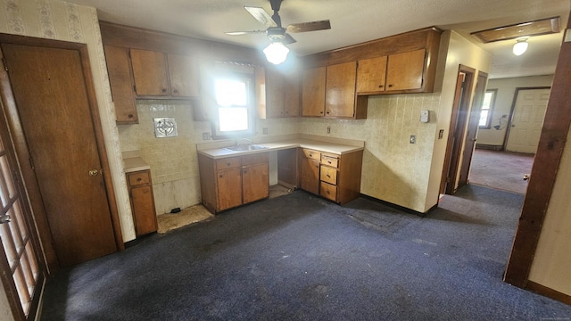 215 Stanley St, New Britain, CT 06051 - kitchen featuring a sink, brown cabinets, dark colored carpet, ceiling fan, and light countertops