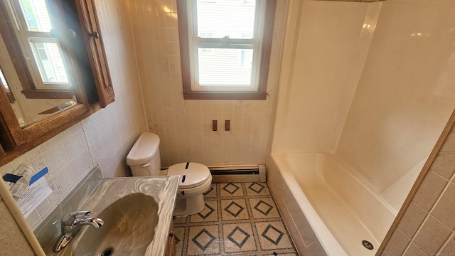 215 Stanley St, New Britain, CT 06051 - bathroom with baseboard heating, toilet, healthy amount of natural light, tile walls, and tile patterned floors
