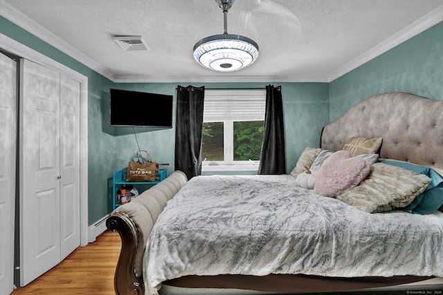 2 Pent Rd, Bloomfield, CT 06002 - bedroom with crown molding, wood finished floors, a textured ceiling, a closet, and a baseboard radiator