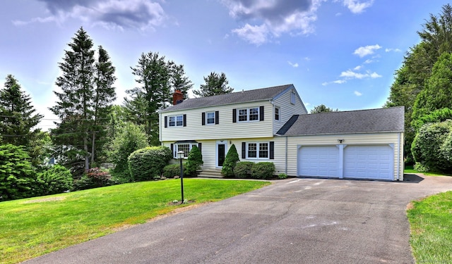 64 Regina St, Trumbull, CT 06611 - colonial home featuring an attached garage, asphalt driveway, a chimney, a front lawn, and roof with shingles