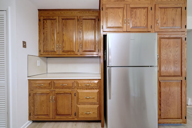 64 Regina St, Trumbull, CT 06611 - kitchen with freestanding refrigerator, brown cabinets, light countertops, and light wood-style flooring