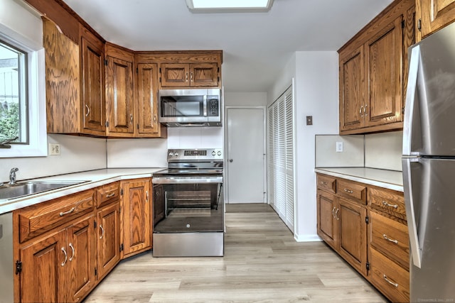 64 Regina St, Trumbull, CT 06611 - kitchen with stainless steel appliances, brown cabinetry, and light wood-style flooring