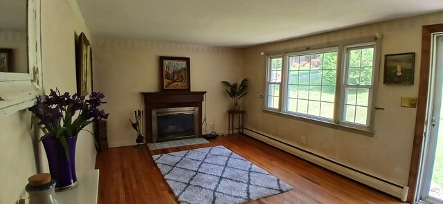 33 Bristol Dr, Canton, CT 06019 - doorway with baseboard heating, wood finished floors, and a fireplace with flush hearth