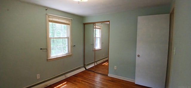33 Bristol Dr, Canton, CT 06019 - unfurnished bedroom with multiple windows, wood finished floors, a closet, and a baseboard heating unit