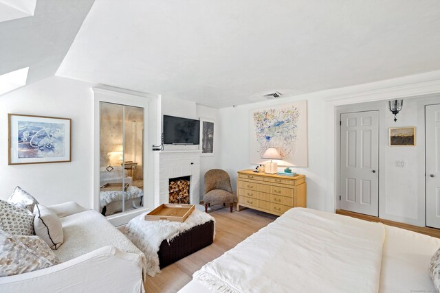 6 Over Rock Ln, Westport, CT 06880 - bedroom with a brick fireplace and light wood-type flooring