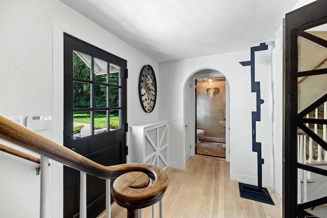6 Over Rock Ln, Westport, CT 06880 - entryway with arched walkways, light wood finished floors, and baseboards