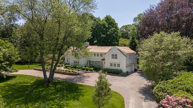 6 Over Rock Ln, Westport, CT 06880 - view of front of house featuring curved driveway, an attached garage, a chimney, and a front lawn