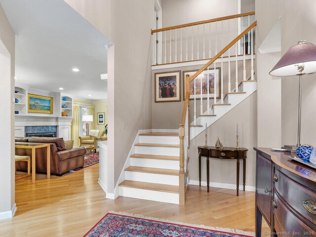 152 Hollyberry Rd, Bristol, CT 06010 - stairs featuring wood finished floors, a tiled fireplace, recessed lighting, and a high ceiling