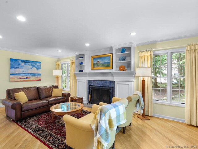 152 Hollyberry Rd, Bristol, CT 06010 - living area with light wood-type flooring, a fireplace, healthy amount of natural light, recessed lighting, and ornamental molding