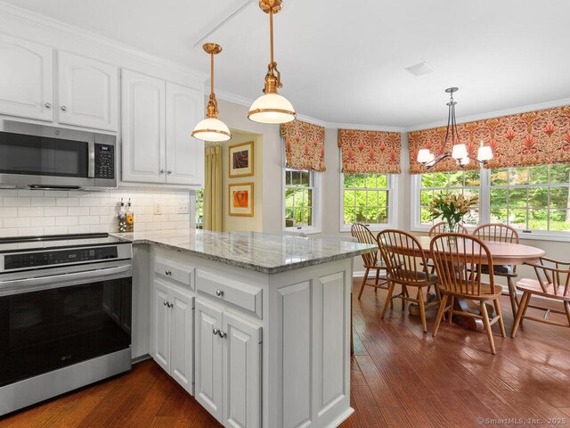 152 Hollyberry Rd, Bristol, CT 06010 - kitchen featuring stainless steel appliances, plenty of natural light, a peninsula, white cabinetry, and ornamental molding