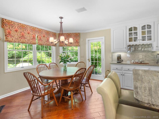 152 Hollyberry Rd, Bristol, CT 06010 - dining area featuring a chandelier, wood finished floors, plenty of natural light, and crown molding