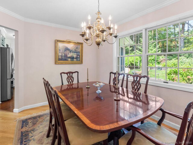 152 Hollyberry Rd, Bristol, CT 06010 - dining area with plenty of natural light, light wood finished floors, a chandelier, and ornamental molding