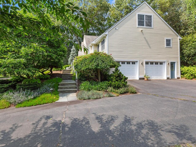152 Hollyberry Rd, Bristol, CT 06010 - view of side of property featuring a garage, driveway, and stairway