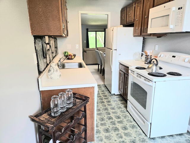 7 Bayberry Ct Unit 7, Cromwell, CT 06416 - kitchen with white appliances, a sink, light countertops, and dark brown cabinetry