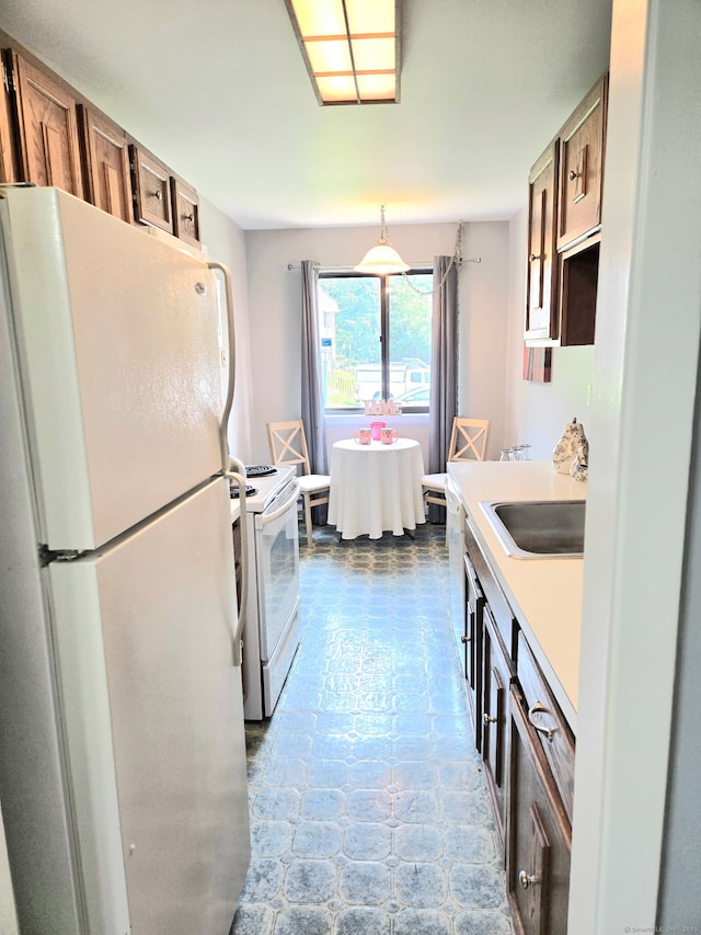 7 Bayberry Ct Unit 7, Cromwell, CT 06416 - kitchen featuring white appliances, a sink, light countertops, brown cabinetry, and pendant lighting