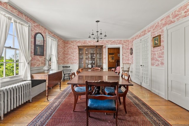 163 Lake Rd, Warren, CT 06754 - dining room with radiator, wallpapered walls, wainscoting, light wood-type flooring, and a chandelier