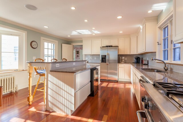 163 Lake Rd, Warren, CT 06754 - kitchen featuring appliances with stainless steel finishes, radiator heating unit, wine cooler, a sink, and dark wood-type flooring