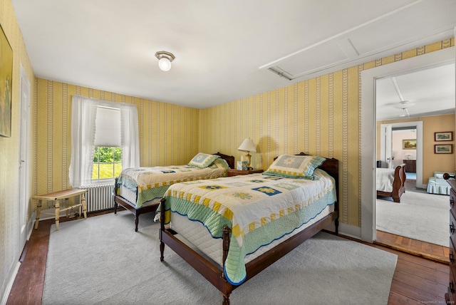 163 Lake Rd, Warren, CT 06754 - bedroom featuring radiator heating unit, wallpapered walls, attic access, and wood finished floors