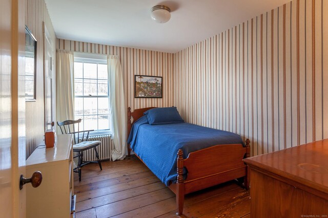 163 Lake Rd, Warren, CT 06754 - bedroom with wallpapered walls, radiator heating unit, and hardwood / wood-style floors