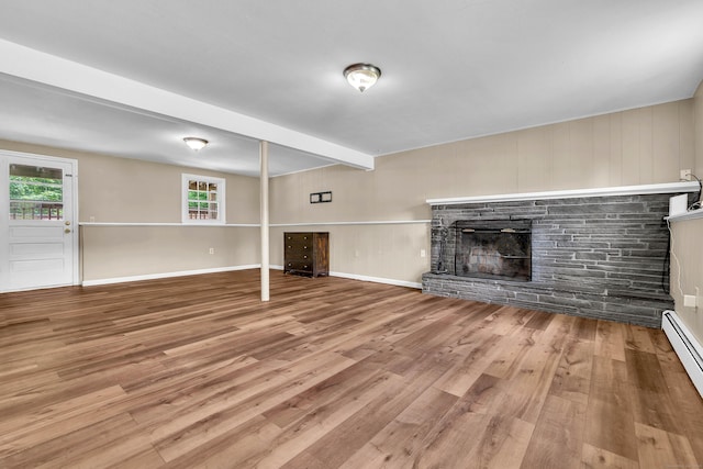 25 Meadow Dr, Ledyard, CT 06335 - unfurnished living room with wood finished floors, a stone fireplace, a baseboard radiator, baseboards, and beamed ceiling