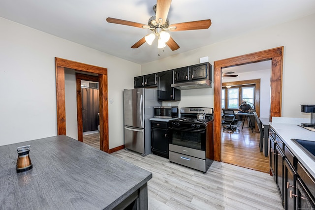 98 Gorham Ave, Hamden, CT 06514 - kitchen with appliances with stainless steel finishes, a ceiling fan, under cabinet range hood, light wood-type flooring, and dark cabinets