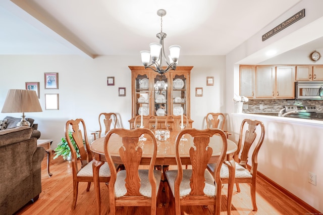 55 Mill Plain Rd Unit 6-3, Danbury, CT 06811 - dining space with a chandelier and light wood-style flooring