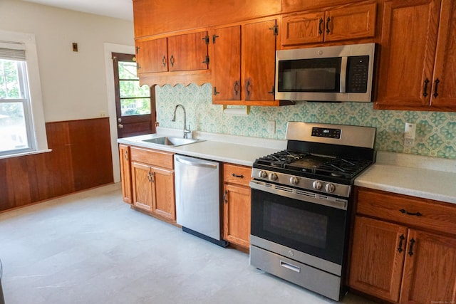 47 Mountford St, Hartford, CT 06114 - kitchen with stainless steel appliances, light countertops, brown cabinets, wainscoting, and light flooring